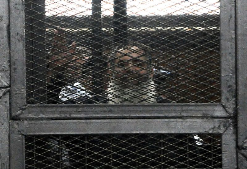 salafi politician hazem salah abu ismail waves from inside the defendants cage during his trial in the egyptian capital cairo on april 16 2014 photo afp
