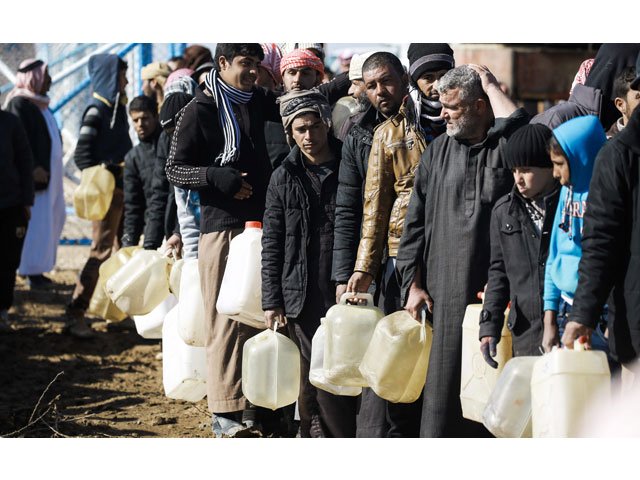 refugees who fled the iraqi city of mosul due to the fighting between government forces and islamic state is group militants queue for heating fuel at the un run al hol refugee camp in syria 039 s hasakeh province on january 29 2017 photo afp