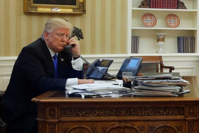 us president donald trump l seated at his desk in the white house photo reuters