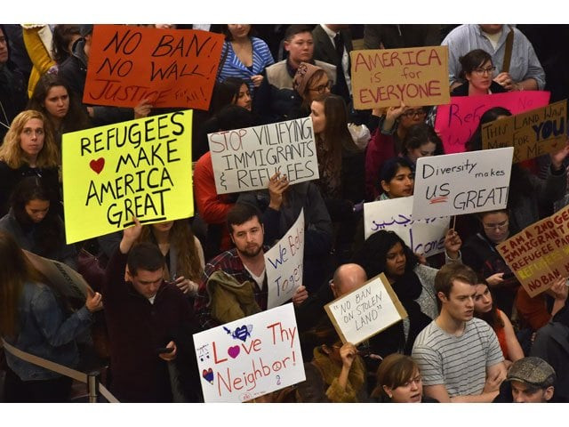 people hold up signs during a protest against us president donald trump 039 s immigration rules at the regan national airport in arlington virginia on february 1 2017 photo afp people hold up signs during a protest against us president donald trump 039 s immigration rules at the regan national airport in arlington virginia on february 1 2017 photo afp