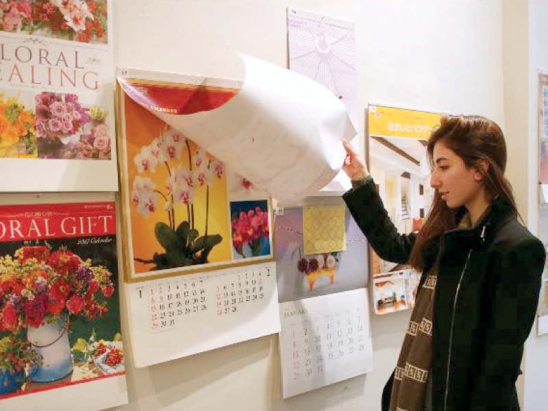 a woman looks at japanese calendars on display at national art gallery photo express