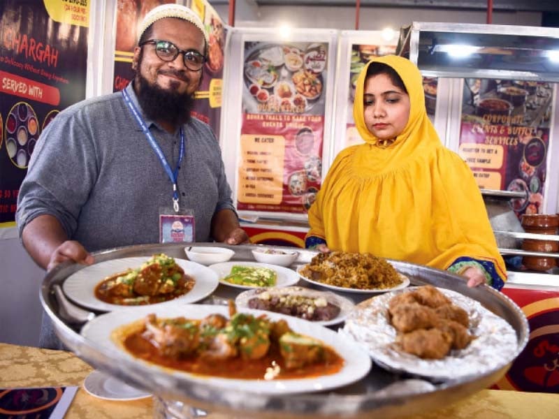 a couple presents their dishes while a woman enjoys traditional pani puri at the bohra food festival which opened at north walk in north nazimabad on friday photos express