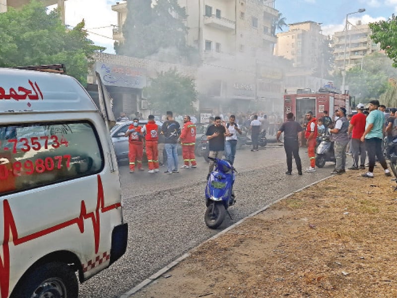 smoke rises from a mobile shop as civil defence members gather in sidon lebanon photo reuters