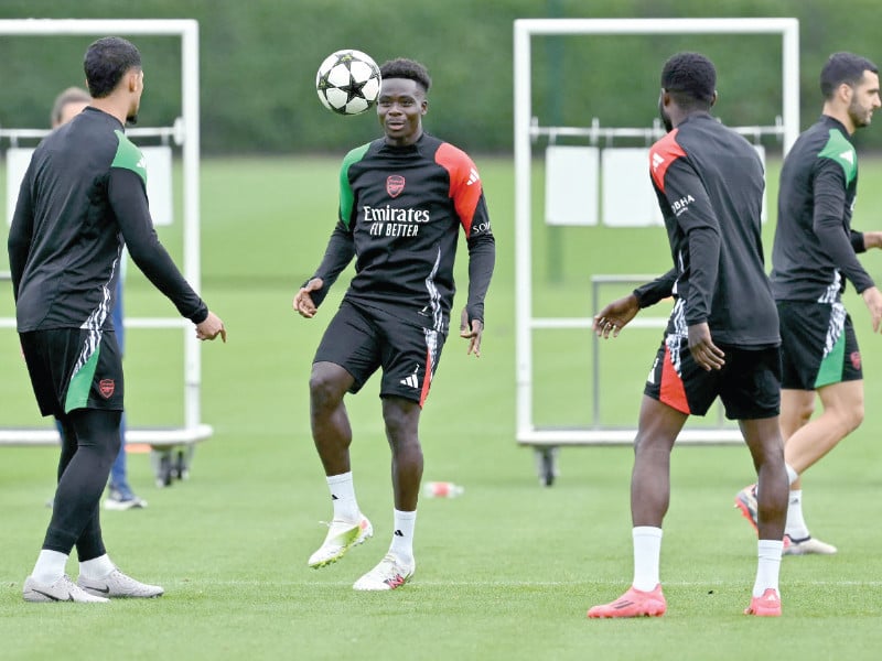 arsenal s midfielder bukayo saka c focuses on the ball as his teammates train in shenley on eve of uefa champions league 1st round match against psg photo afp