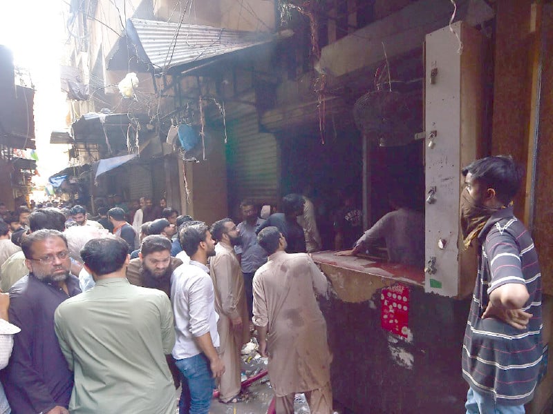 shopkeepers look at their goods lost in an inferno that swept through the bolton market on tuesday photo inp