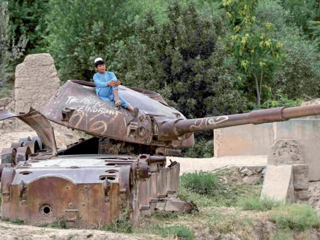 an afghan boy sits atop a soviet era military tank in kishim district of afghanistan s badakhshan province photo afp an afghan boy sits atop a soviet era military tank in kishim district of afghanistan s badakhshan province photo afp
