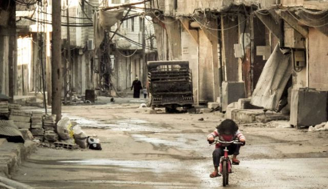 a syrian girl rides her bicycle in an almost deserted street in the teshrin neighborhood of the qabun area in damascus photo afp a syrian girl rides her bicycle in an almost deserted street in the teshrin neighborhood of the qabun area in damascus photo afp