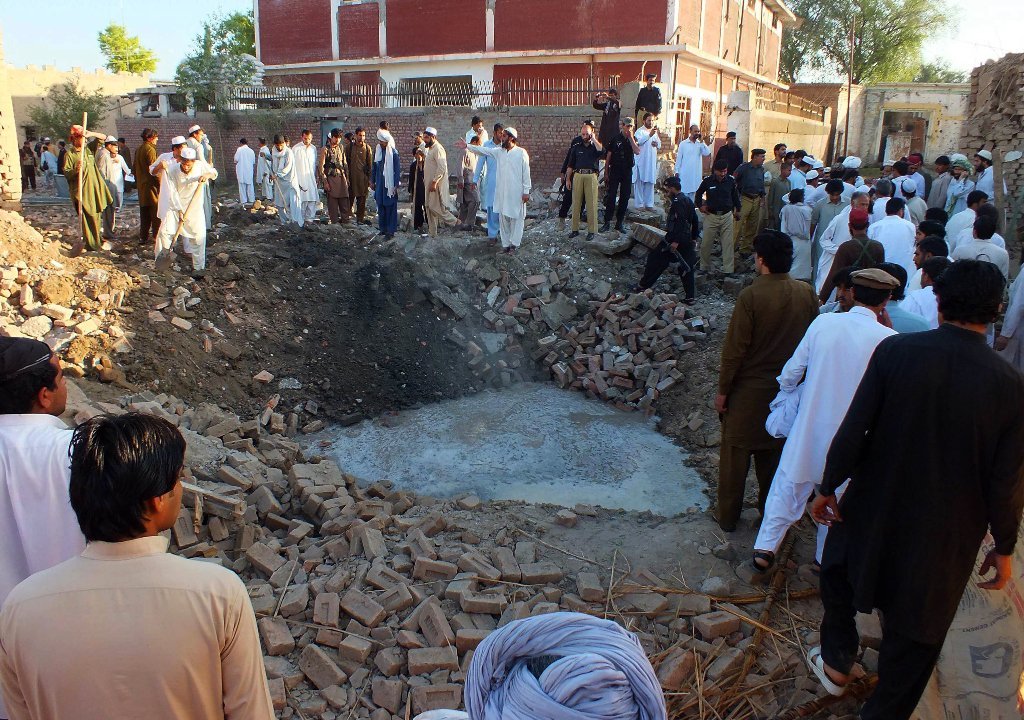security officials and local residents gather at the site of a suicide bombing in the town of bannu in khyber pakhtunkhwa province on may 8 2013 photo afp