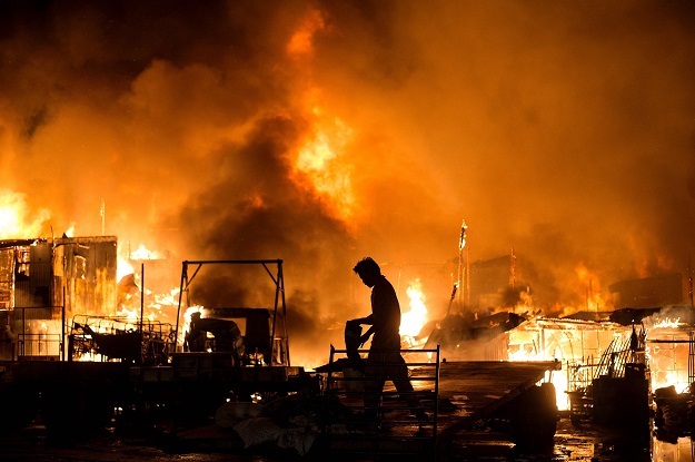 residents look on as a fire destroys hundreds of houses at an informal settlers community in delpan tondo manila on february 7 2017 photo afp