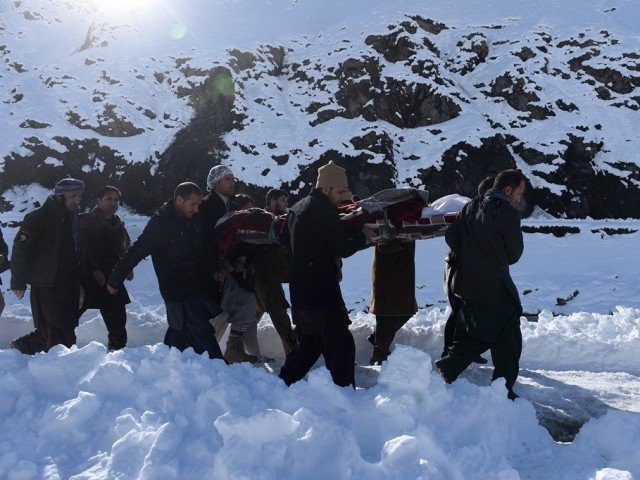 afghan men carry the body of a victim of avalanches after funeral prayers in khench district of panjshir province north of kabul on february 26 2015 photo afp