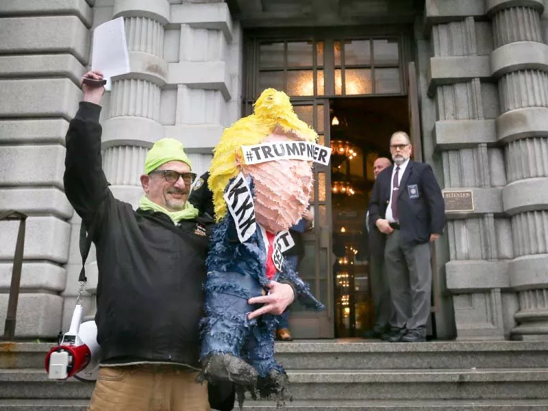 an anti trump protester holds up a copy of the appeals court s decision photo afp an anti trump protester holds up a copy of the appeals court s decision photo afp