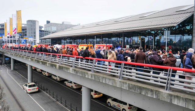 firefighters with multiple vehicles stand in front of hamburg airport as passengers leave the terminal on february 12 2017 in hamburg northern germany as german emergency services evacuated the airport after people reported an unusual smell as well as respiratory ailments and watering eyes photo afp