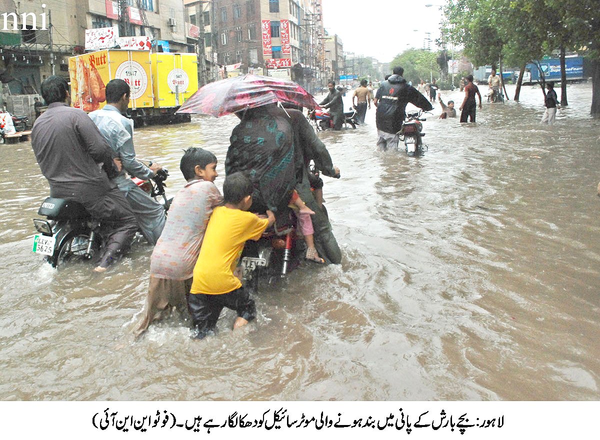 children pushing a motorbike as it struggles to make way in floodwaters in lahore photo nni