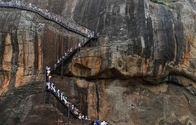 sri lankans and tourists climb the 80 metre 600 foot fortress of sigiriya rock the lion rock in sigiriya north central sri lanka the sigiriya rock 160 kilometres 100 miles north of colombo is a world heritage site known for frescoes of bare chested women photo afp