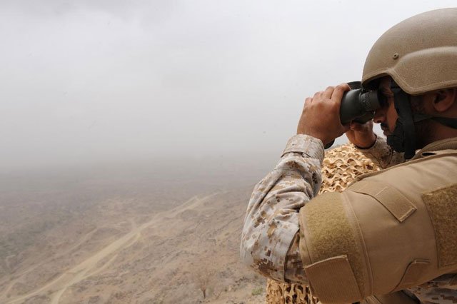 a saudi soldier looks through binoculars from a position on the saudi yemeni border in southwestern saudi arabia on april 13 2015 photo afp