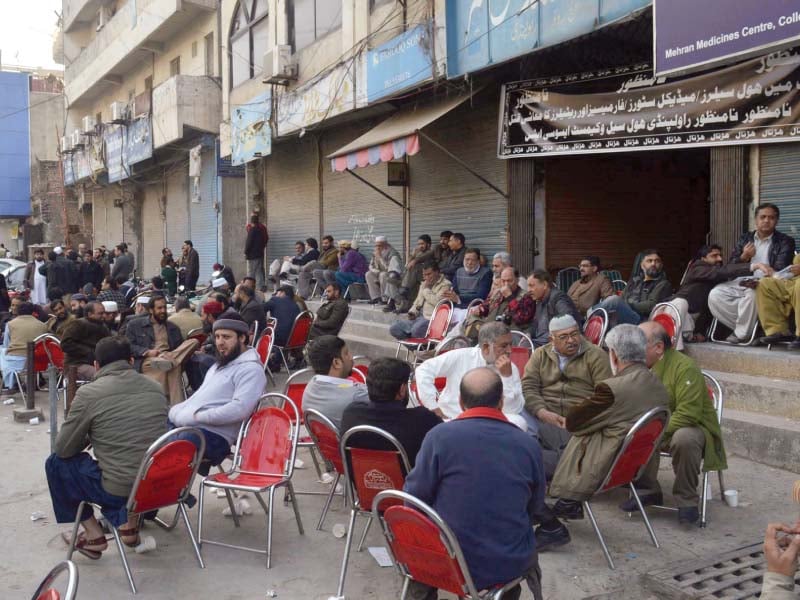 owners employees of medical stores sit outside their shops photo zafar aslam express