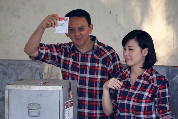 governor of indonesia 039 s capital basuki tjahaja purnama l shows his ballot as he stands beside his wife veronica tan during an election for jakarta 039 s governor in jakarta indonesia february 15 2017 photo reuters