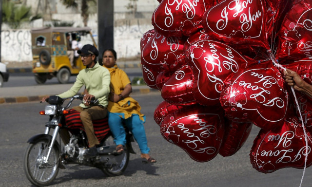 a couple on a motorcycle ride past a vendor selling heart shaped balloons on valentine 039 s day photo reuters a couple on a motorcycle ride past a vendor selling heart shaped balloons on valentine 039 s day photo reuters