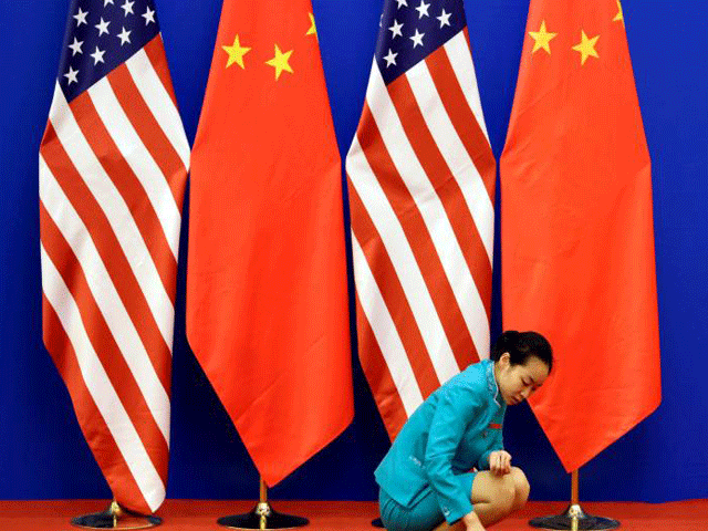 an attendant cleans the carpet next to us and chinese national flags before a news conference for the 6th round of us china strategic and economic dialogue at the great hall of the people in beijing july 10 2014 photo reuters file