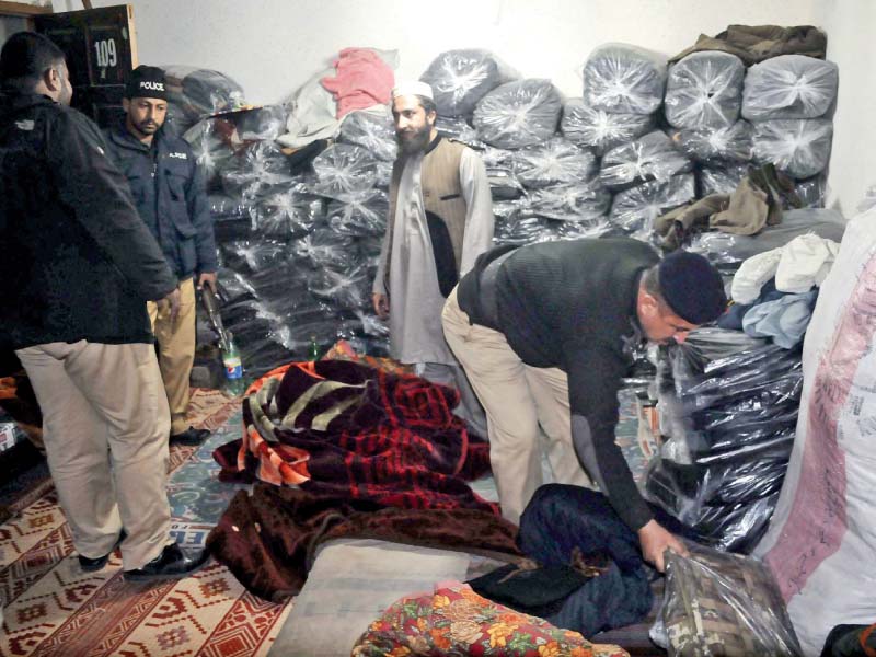 policemen search a warehouse in the remits of city police station in rawalpindi photo ppi