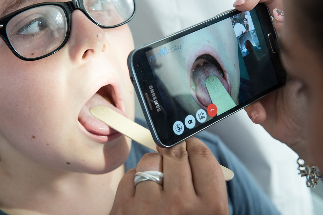 doctor thierry castera examines the throat of a child via a smartphone held by a nurse during a digital medical consultation photo afp