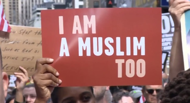 holding placards featuring a hijabi woman in an american flag captioned we the people are greater than fear and signs reading i am a muslim too the demonstrators paraded around new york s most famous spot screengrab