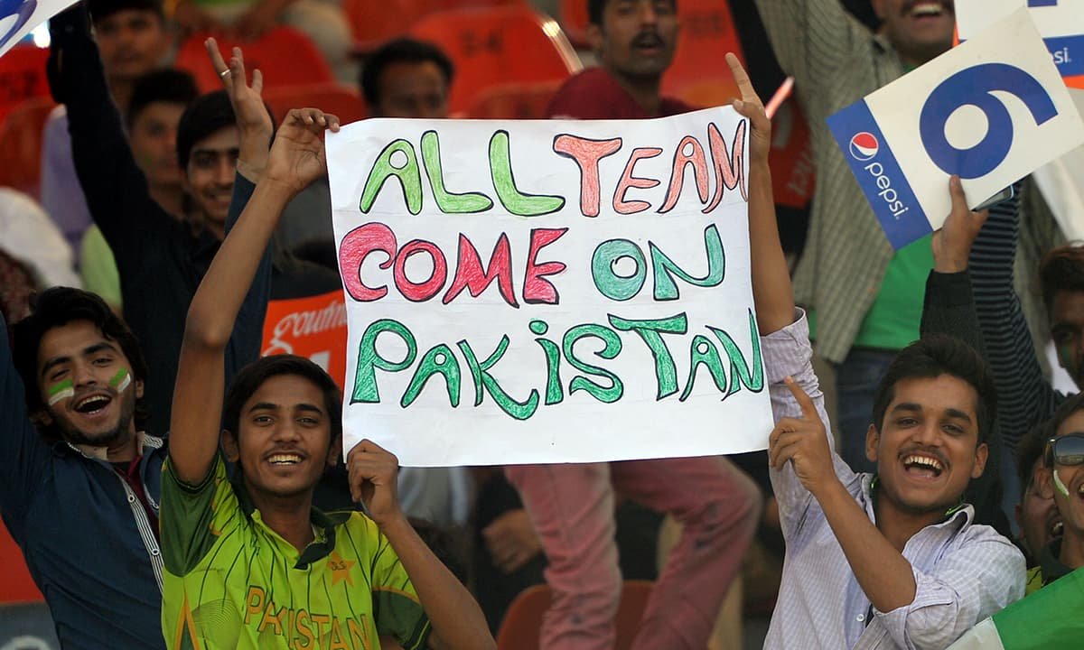 pakistani spectators carry a placard before starting the first one day international match between pakistan and zimbabwe at the gaddafi cricket stadium in lahore on may 26 2015 photo afp