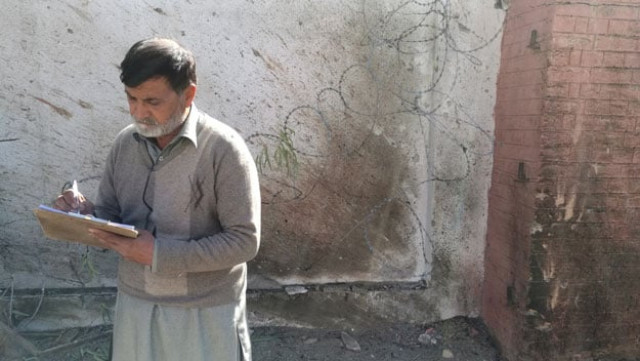 an officer takes notes outside a courthouse after an attack by suicide bombers in charsadda on tuesday photo reuters an officer takes notes outside a courthouse after an attack by suicide bombers in charsadda on tuesday photo reuters