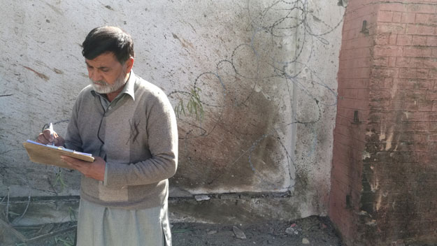 an officer takes notes outside a courthouse after an attack by suicide bombers in charsadda on tuesday photo reuters