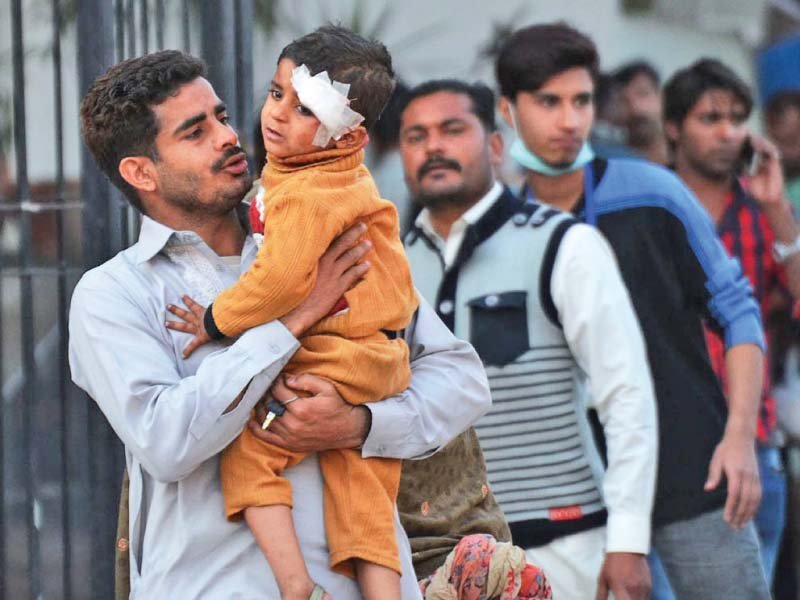 a man at lahore general hospital comforts an injured child photo online