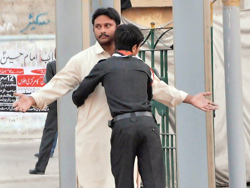 a volunteer frisks a man outside the shah e khurasan imambargah on monday security outside imambargahs has been increased with walkthrough gates installed at a considerable distance from the mosques photo express