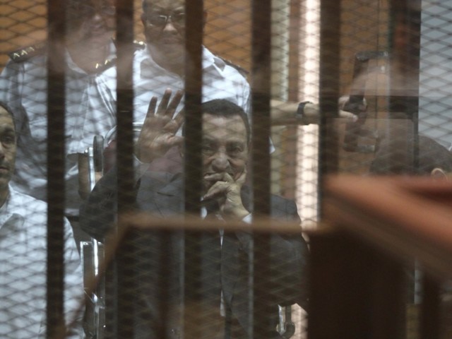 egypt 039 s deposed president hosni mubarak waves from behind the accused cage during his trial on may 21 2014 in cairo photo afp