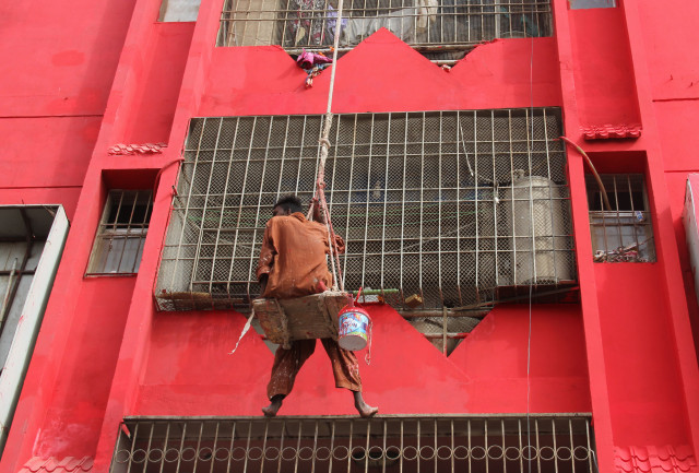 a graffitist dangles off a wooden plank supported by a ladder and some concrete bricks as he paints the facade of a high rise building near sakhi hassan chowrangi in karachi this trend of painting advertisements over buildings emerged after the courts placed a blanket ban on billboards last year photos ayesha mir express a graffitist dangles off a wooden plank supported by a ladder and some concrete bricks as he paints the facade of a high rise building near sakhi hassan chowrangi in karachi this trend of painting advertisements over buildings emerged after the courts placed a blanket ban on billboards last year photos ayesha mir express