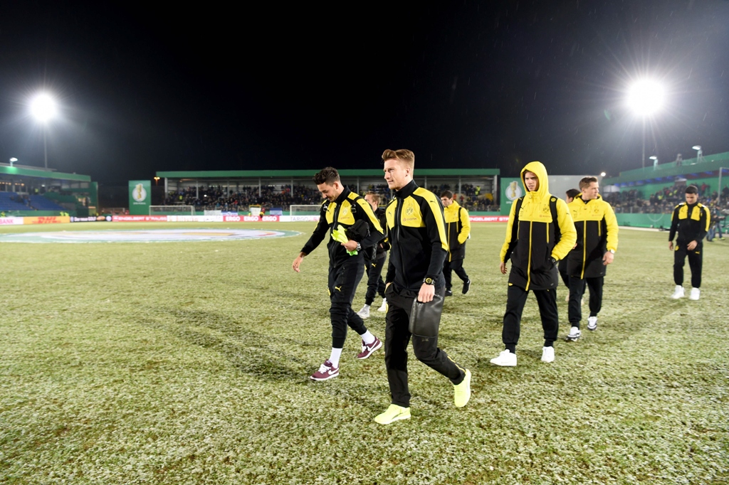 dortmund players walk over the pitch after the match was cancelled on february 28 2017 photo afp