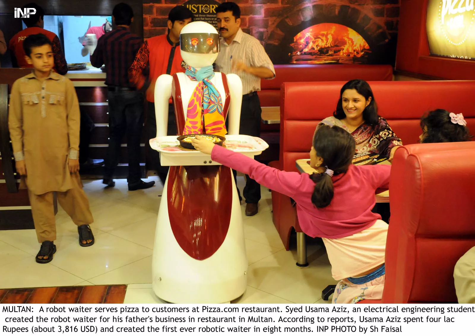 the robot waiter serves pizza to the customers at the outlet in multan photo inp the robot waiter serves pizza to the customers at the outlet in multan photo inp