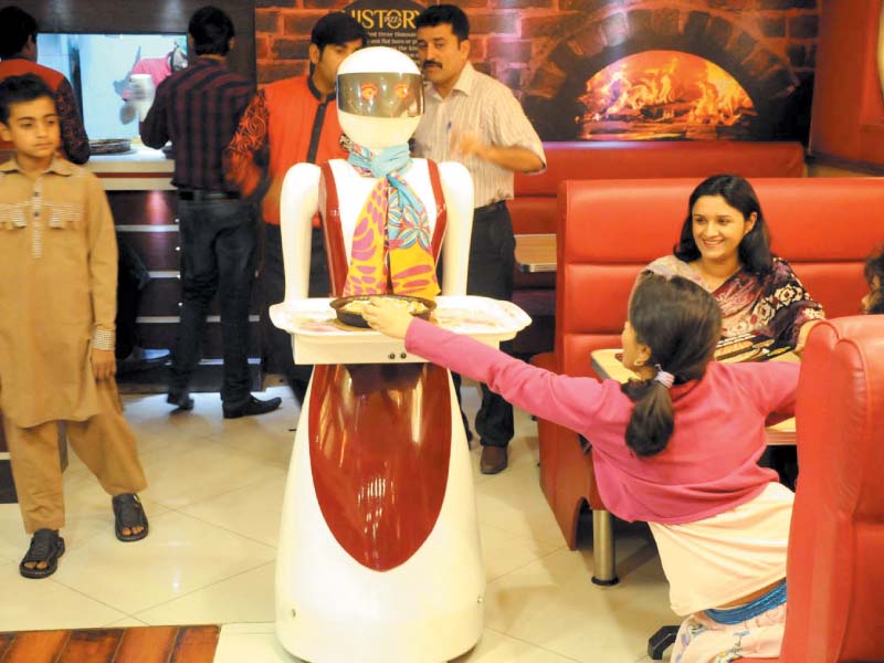 customers wait anxiously to be served by the robot waiter at pizza com photo inp