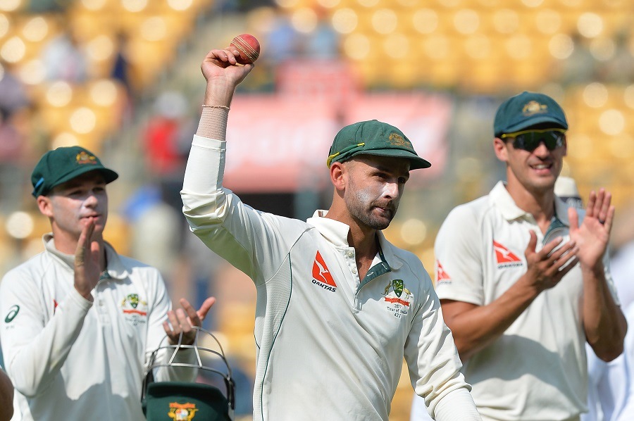 nathan lyon shows the ball as his teammates applaud after his eight wicket haul photo afp
