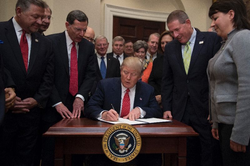 us president donald trump c signs the the waters of the us wotus executive order aimed at killing the obama administration 039 s contentious clean water rule at the white house in washington dc february 28 2017 photo afp