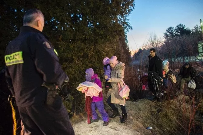 police officers look on as a family from turkey illegally crosses the us canada border just before dawn on february 28 2017 photo afp police officers look on as a family from turkey illegally crosses the us canada border just before dawn on february 28 2017 photo afp