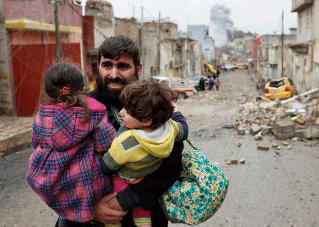 a man carries his children as he walks from islamic state controlled part of mosul towards iraqi special forces soldiers during a battle in mosul iraq march 4 2017 photo reuters