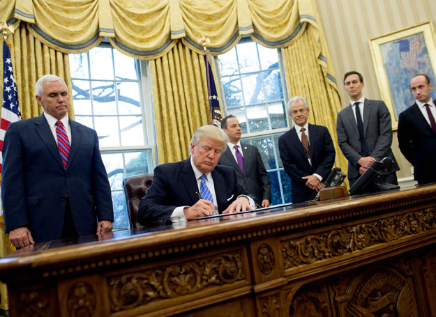 this file photo taken on january 23 2017 shows us president donald trump signing an executive order alongside white house chief of staff reince priebus c us vice president mike pence l national trade council advisor peter navarro 3rd r senior advisor jared kushner 2nd r and senior policy advisor stephen miller in the oval office of the white house in washington dc january 23 2017 photo afp