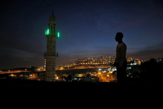 a man stands near a mosque opposite to a neighborhood in east jerusalem photo reuters a man stands near a mosque opposite to a neighborhood in east jerusalem photo reuters