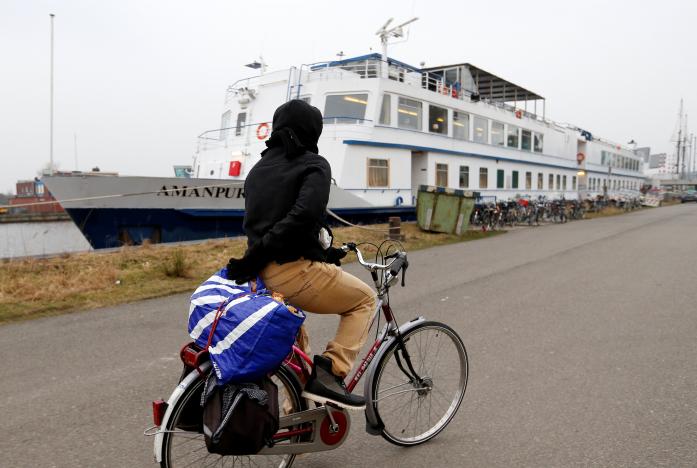 moussa sall from guinea rides a bicycle outside floating hotel quot amanpuri quot housing migrants whose asylum procedure has been declined in groningen netherlands photo reuters