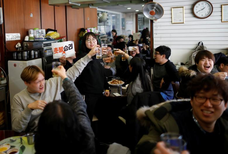 people make a toast as they celebrate after hearing that president park geun hye 039 s impeachment was accepted at a restaurant near the presidential blue house in seoul south korea march 10 2017 the sign reads quot we won quot photo reuters