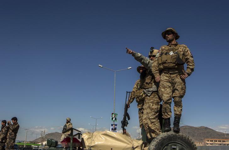 members of afghan special forces stand as one of them points at the site of an attack in kabul march 25 2014 photo reuters