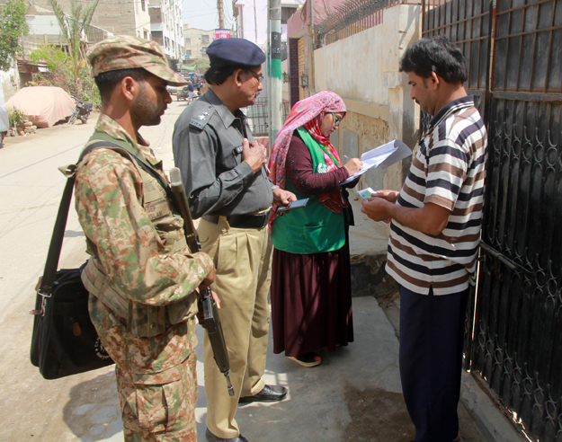 census officials accompanied by law enforcers carry out their duties in district malir photo athar khan express