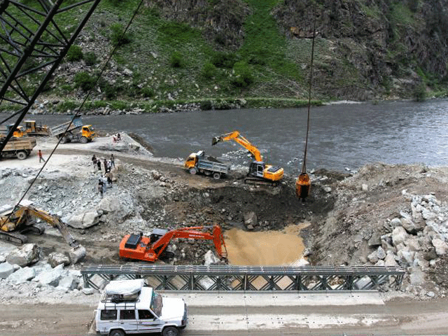 a private vehicle crosses a bridge as excavators are used at the dam site of kishanganga power project in gurez 160 km 99 miles north of srinagar june 21 2012 photo reuters