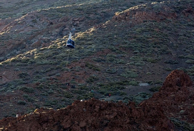 a person hangs from a rope beneath a cable car booth after 60 tourists became trapped in the two booths that ascend the el teide volcano 3718 meters in the el teide national park on the spanish canary island of tenerife on march 15 2017 photo afp a person hangs from a rope beneath a cable car booth after 60 tourists became trapped in the two booths that ascend the el teide volcano 3718 meters in the el teide national park on the spanish canary island of tenerife on march 15 2017 photo afp