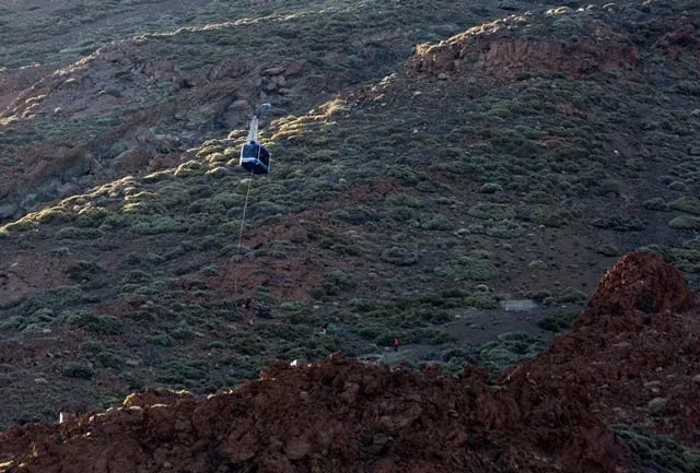 a person hangs from a rope beneath a cable car booth after 60 tourists became trapped in the two booths that ascend the el teide volcano 3718 meters in the el teide national park on the spanish canary island of tenerife on march 15 2017 photo afp a person hangs from a rope beneath a cable car booth after 60 tourists became trapped in the two booths that ascend the el teide volcano 3718 meters in the el teide national park on the spanish canary island of tenerife on march 15 2017 photo afp