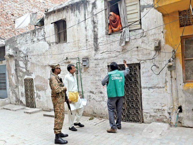 accompanied by a military soldier an official from the pakistan bureau of statistics marks a house in the provincial capital photo afp